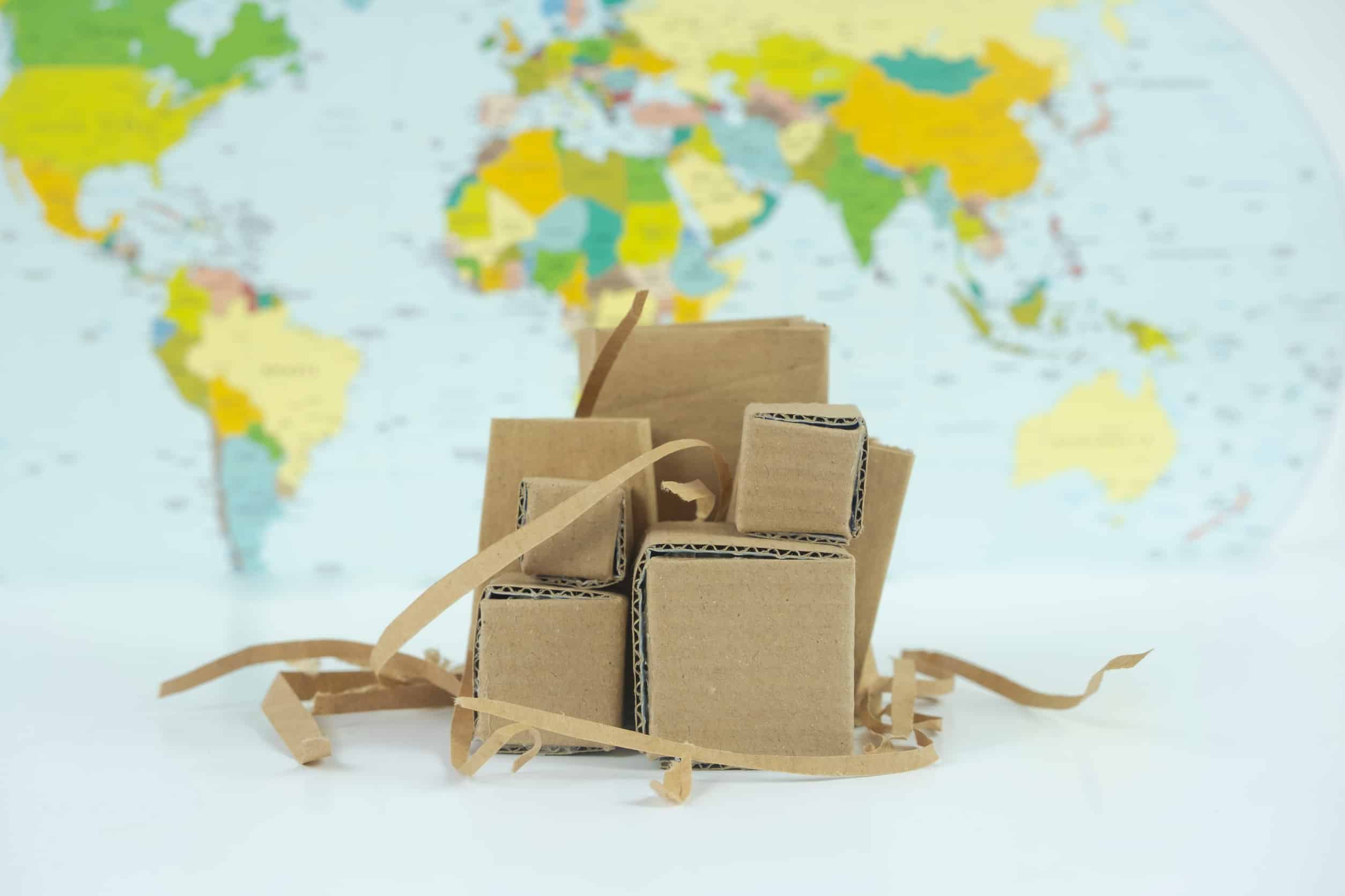 Paper box on world map background – Delivery and logistics concept